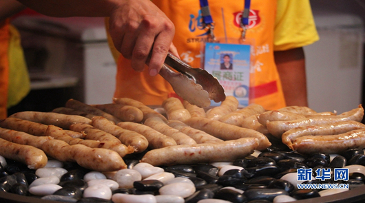 【組圖】兩岸特色廟會以“食”會友 兩岸各大夜市的招牌美食集聚特色廟會,圖為鵝卵石上的香腸,香氣四溢。新華網(wǎng) 劉默……