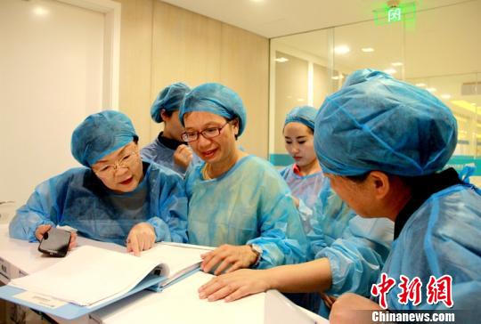 圖為:海峽兩岸孕產專家到產房護士站翻看待產記錄和入院待產評估。 劉子裕 攝