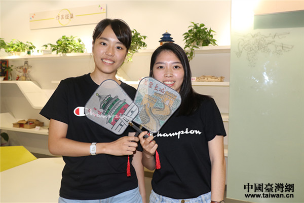 就讀臺北藝術大學音樂系的白竹君在扇面上手繪長城,就讀臺灣“中國科技大學”的蔡昀芷在扇面上手繪祈年殿 就讀臺北藝術大學音樂系的白竹君在扇面上手繪長城,就讀臺灣“中國科技大學”的蔡昀芷在扇面上手繪祈年殿