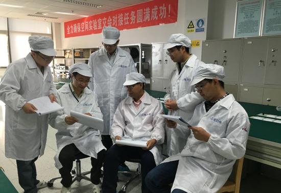 孫武(右三)和蔣清富(左二)帶領(lǐng)團(tuán)隊(duì)為交會(huì)對(duì)接做準(zhǔn)備