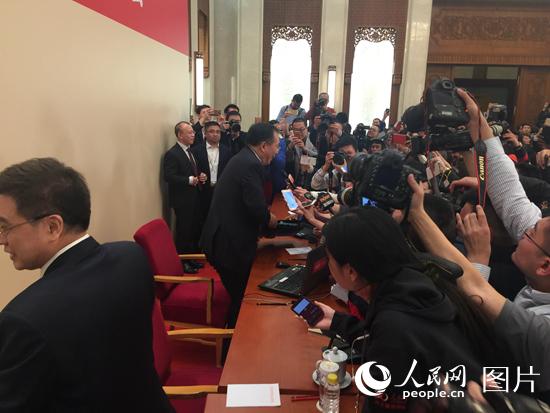 發布會結束后王國慶被記者“包圍”。人民網趙艷紅 攝