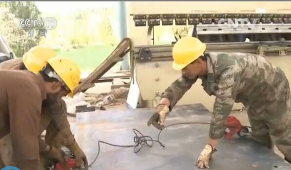 工人瓦卡爾正在跟他的中國師傅李保國學(xué)習(xí)機(jī)械操作。