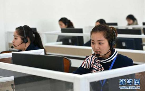 2015年2月14日,淮安市公安局陽光警務平臺“人工訪評中心”工作人員莊陽陽對服務對象所涉及事項的辦結情況進行電話回訪。新華社發(周洪明 攝)