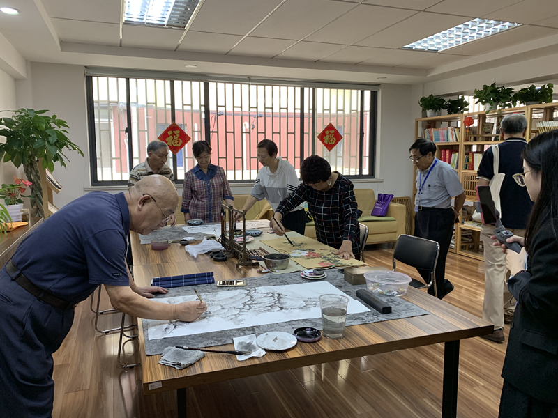 人們在上海市楊浦區遼源西路的睦鄰中心揮毫潑墨。(央視網 鄭芳 攝)