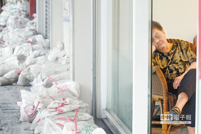 高雄凱旋路上連日大雨導致民宅積水,家家戶戶堆起沙包,阿嬤擔心地倚在門邊,不知何日天晴 高雄凱旋路上連日大雨導致民宅積水,家家戶戶堆起沙包,阿嬤擔心地倚在門邊,不知何日天晴