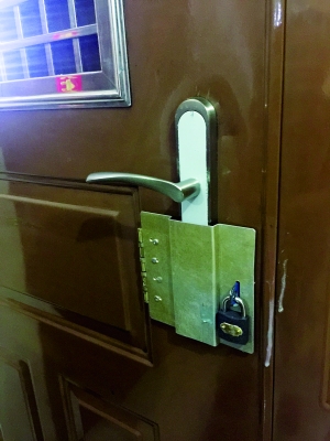 ②王女士在防盜門鎖外用鐵皮打了罩子,再用鎖鎖起來。