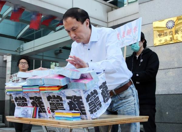 國民黨主席候選人李新提議“黨產(chǎn)歸零,黨員分配”,在記者會上推倒象征黨產(chǎn)的墻